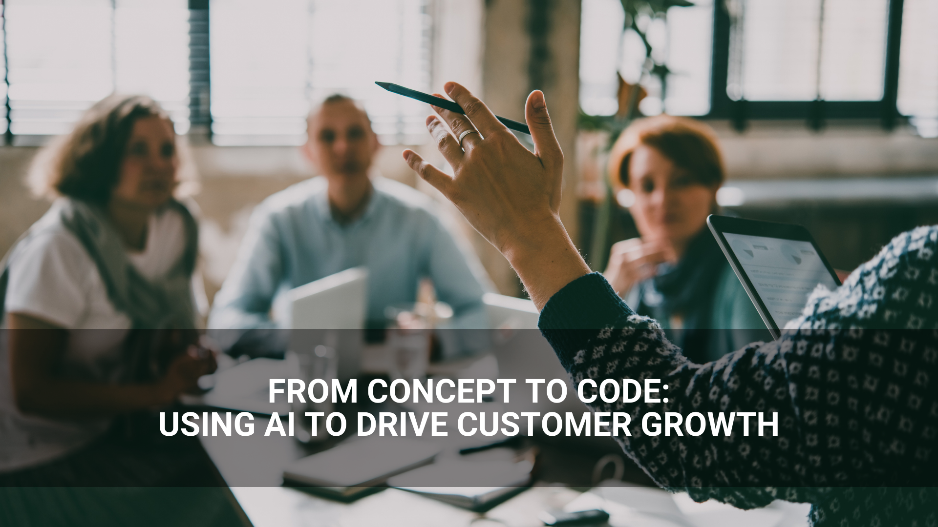 A person gestures during a meeting with three colleagues in an office. The text reads, "From concept to code: Harnessing AI to drive customer growth.