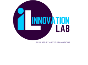 Logo of Innovation Lab for the Main Page, featuring a dark circle with a blue letter 'i' and a white letter 'L'. The text "Innovation Lab" is displayed beside the circle with the tagline "Powered by Above Promotions". Updated for 2024.