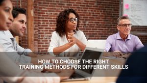 Four people sit at a conference table with laptops and notes. Text overlay reads, "How to Choose the Right Training Methods and Skills Assessment for Different Skills.