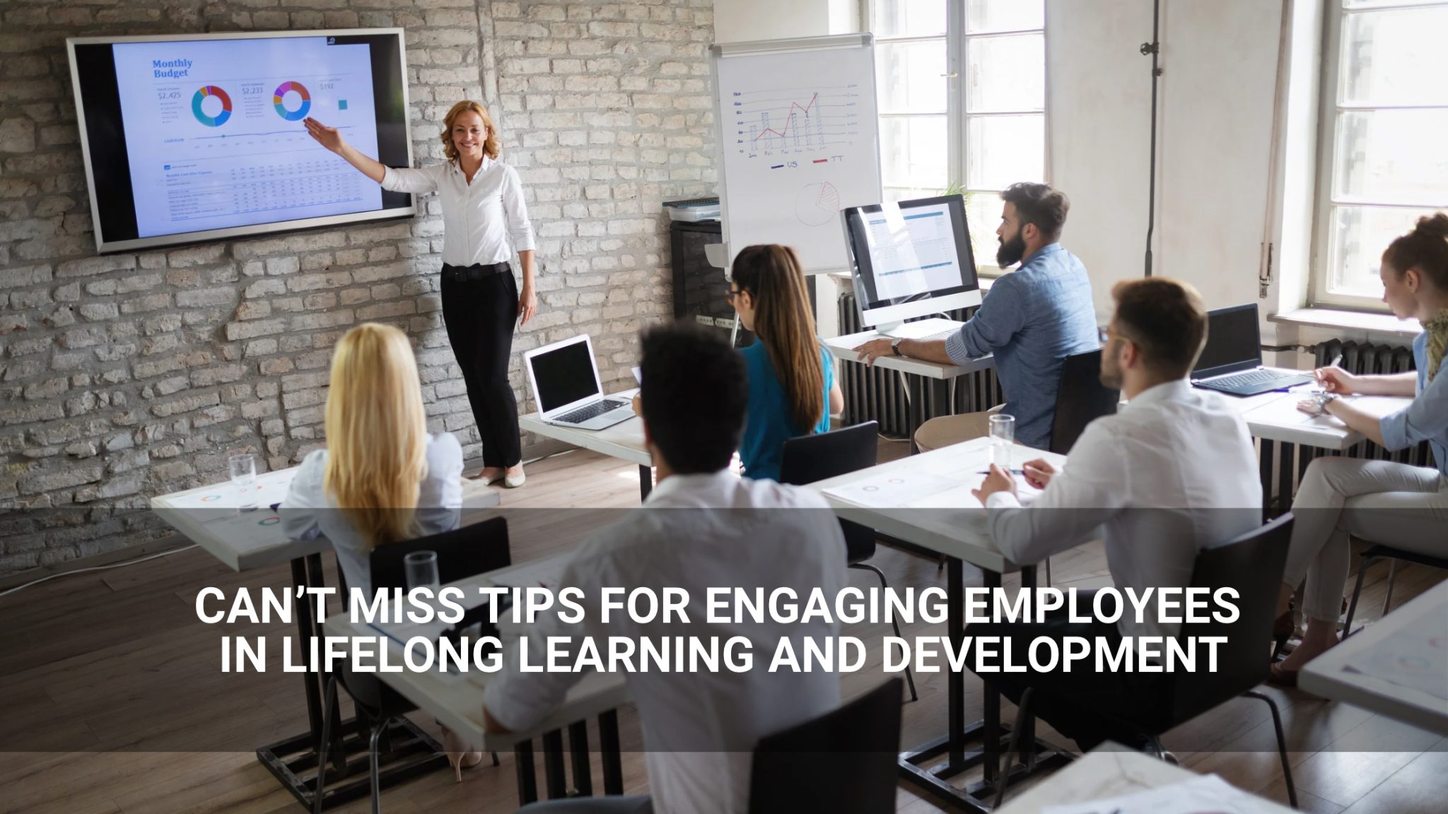 Can’t miss tips for engaging employees in lifelong learning and employee development. - employees gathered to look at graphs on screen. - Above Promotions